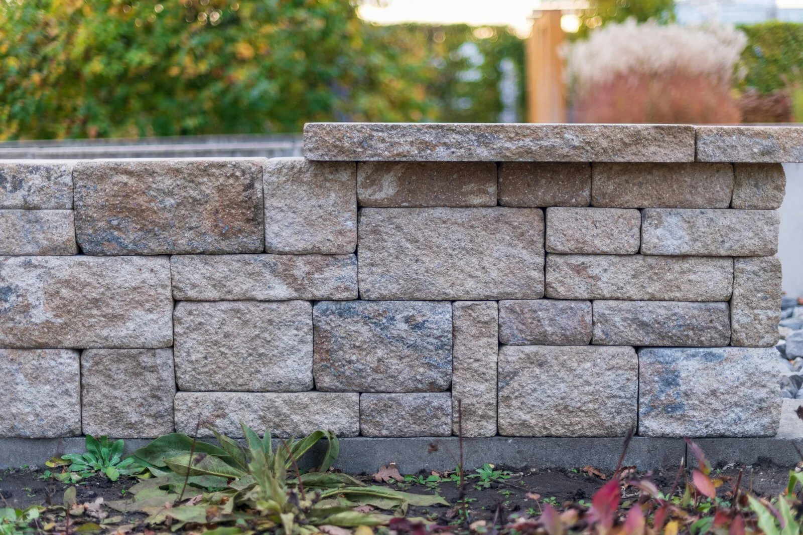 Block retaining wall holding back a sloped grade change